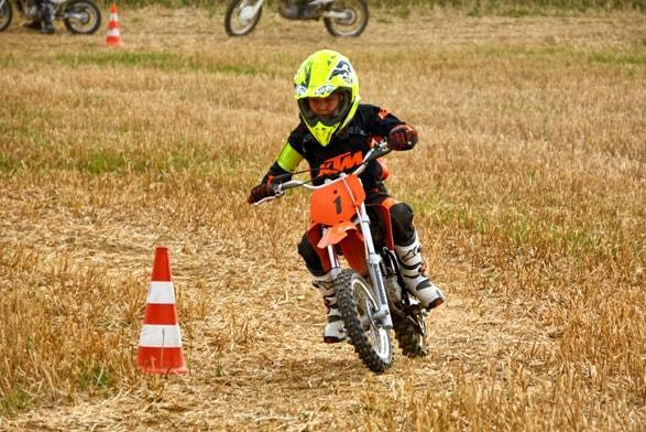 Kinder Motocross: Kind übt mit dem Motorrad zwischen Pylonen